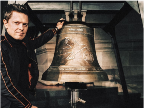 Dieses Foto zeigt Michael Patrick Kelly mit der PeaceBell. 